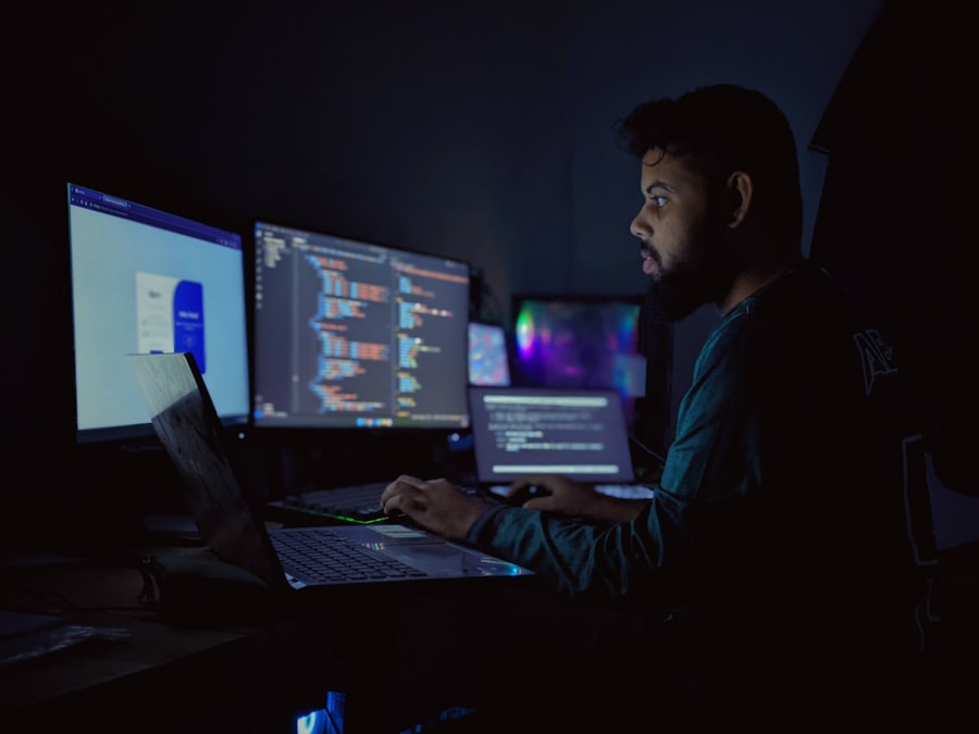A developer at a multi-monitor desk working through code late in the day