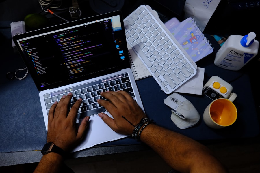 Hands resting on a keyboard while a person reviews work shown on the screen