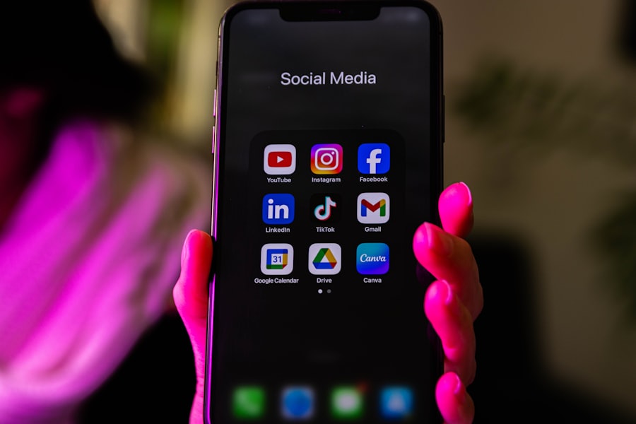 A hand holding a phone that shows a grid of colorful app icons on its screen