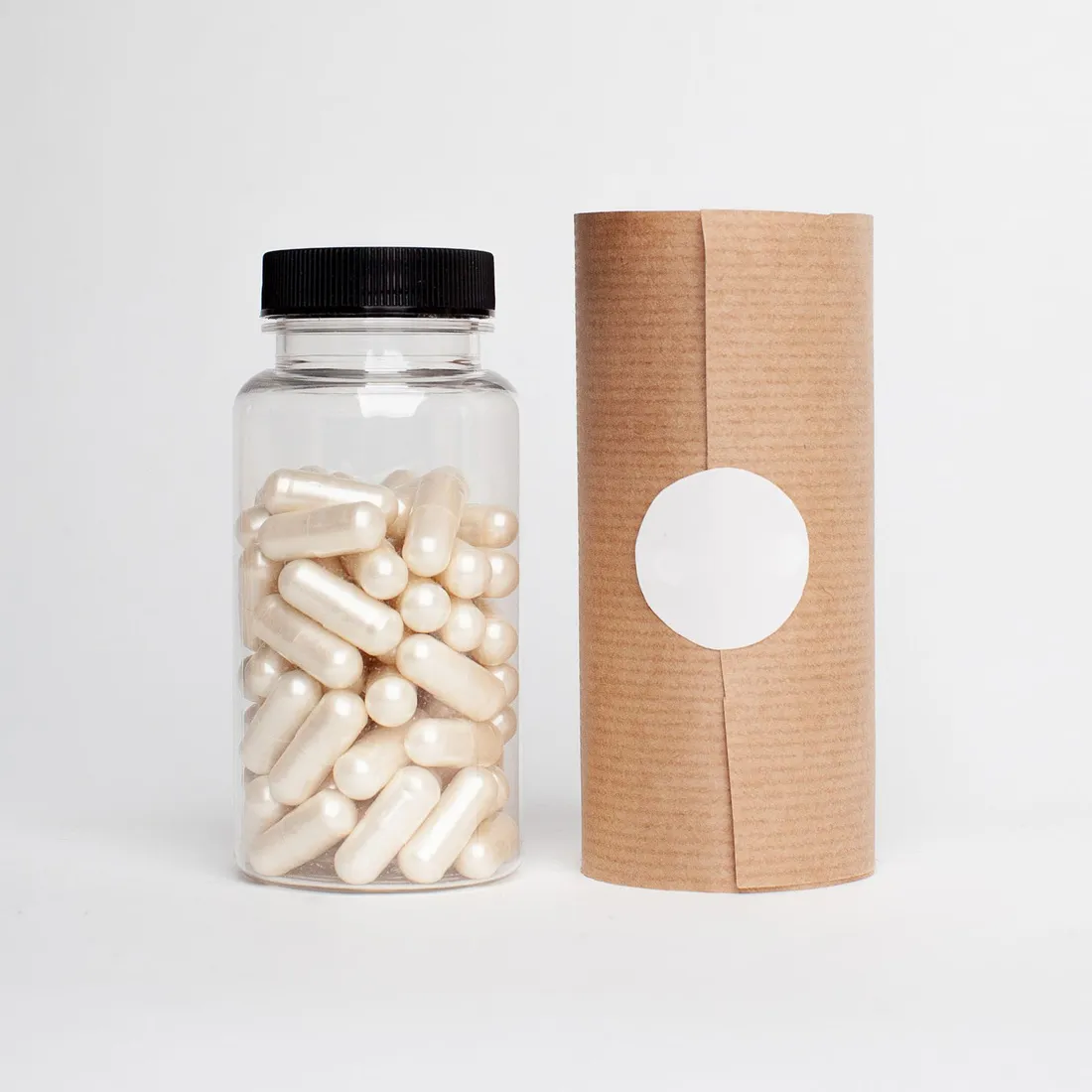Capsules in a plastic bottle on a light surface